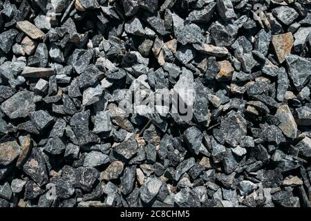 Grobe Steine, Schotter, Granitkies Nahaufnahme. Die raue Textur des Steins. Hintergrund des Baumaterials. Struktur Stockfoto
