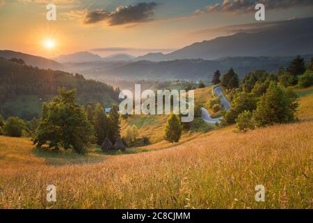 Sommersonnenaufgang im siebenbürgischen Dorf. Luftnebellandschaft in Siebenbürgen, bei Sonnenaufgang Stockfoto