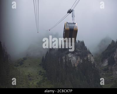 Seilbahn von Wengen nach Mannlichen steigt aus dem Nebel auf der Spitze des Berges. Wengen, Berner Oberland, Schweiz Stockfoto