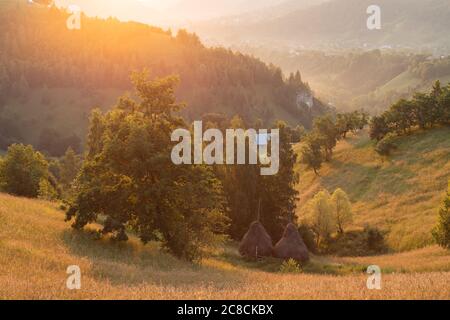 Sommersonnenaufgang im siebenbürgischen Dorf. Luftnebellandschaft in Siebenbürgen, bei Sonnenaufgang Stockfoto