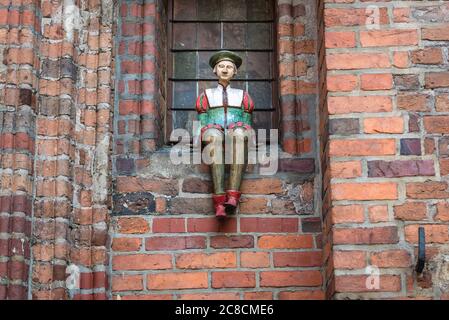 Eine von vielen Keramikfiguren des Bürgers an der Wand des gotischen alten Rathauses in der Altstadt von Torun, Woiwodschaft Kujawien Pommern in Polen Stockfoto