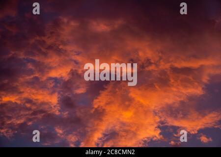 Wolken am Himmel bei Sonnenuntergang orange gemalt Stockfoto