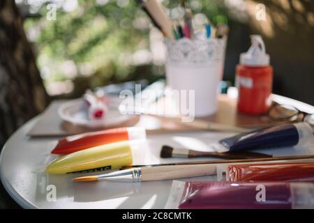Tuben und Pinsel auf weißem Tisch malen Stockfoto