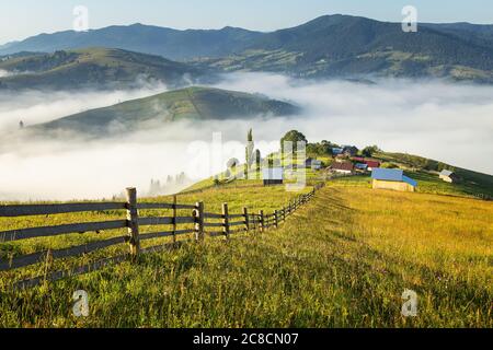 Sommersonnenaufgang im siebenbürgischen Dorf. Luftnebellandschaft in Siebenbürgen, bei Sonnenaufgang Stockfoto