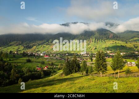 Sommersonnenaufgang im siebenbürgischen Dorf. Luftnebellandschaft in Siebenbürgen, bei Sonnenaufgang Stockfoto