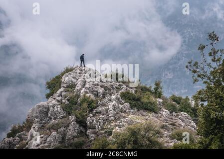 Tourist auf einem Felsen in Blouza Dorf oberhalb Kadisha Tal auch als Heilige Tal im Norden Governorate des Libanon Stockfoto
