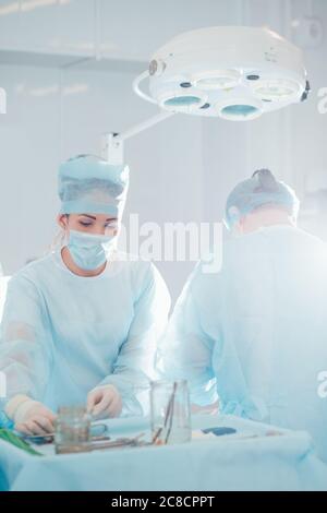 Junge Frau trägt Maske Chirurg Operation Stockfoto