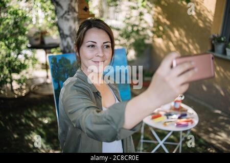 Lächelndes Mädchen, das Selfie in der Outdoor-Werkstatt nimmt Stockfoto