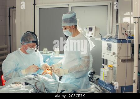 Team von Chirurgen in Uniform führen Operation an einem Patienten in der Klinik für plastische Chirurgie Stockfoto