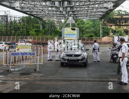 Kalkutta, Indien. Juli 2020. Kolkata Polizisten mit Masken werden an einem Kontrollpunkt gesehen, der Dokumente von Reisenden auf der Straße während der zweitägigen Sperrung pro Woche überprüft.die Regierung von Westbengalen beschloss, eine Woche im Staat zu sperren, um den Anstieg der Coronavirus-Krankheit (COVID-19) einzudämmen. Nur Personen im Rettungsdienst und Patienten haben die Erlaubnis, zu reisen oder Bewegungen zu machen. Kredit: SOPA Images Limited/Alamy Live Nachrichten Stockfoto