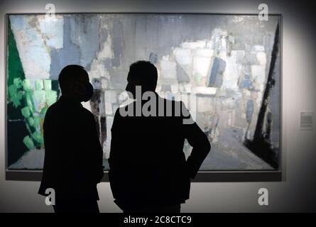 Besucher mit Gesichtsmaske können während der Ausstellung Nicolas de Staël im Museum Centre Pompidou vor einem Gemälde chatten.EINE neue Retrospektive über den französischen Maler Nicolas de Staël mit 25 Werken, 9 Gemälden und 16 Papierarbeiten kommt im Museum Pompidou an. Diese Ausstellung wurde vom Präsidenten des französischen Pompidou Museums Serge Lasvignes, dem französischen Botschafter Jean-Michel Casa und dem Bürgermeister der Stadt Málaga, Francisco de la Torre, präsentiert. Die Ausstellung zeigt die Karriere des Künstlers durch seine figurativen und abstrakten Gemälde und Werke und es wird in Malaga vom 23. Juli bis 8 Nove zeigen Stockfoto