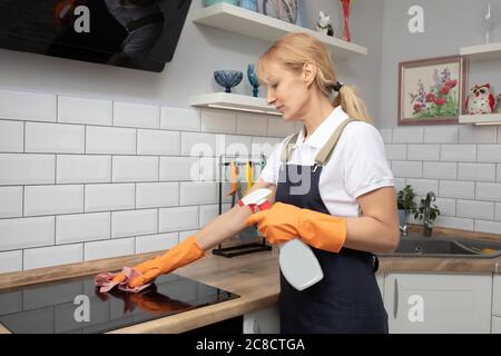 Eine Frau Putzfrau oder Hausfrau Reinigung Induktionsherd in Küche zu Hause Stockfoto