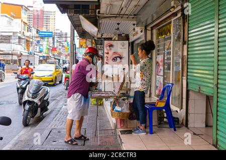 Ein Mann kauft eine Lotterie-Karte an einem Straßenschalter. Asiatische Traditionen. Stockfoto