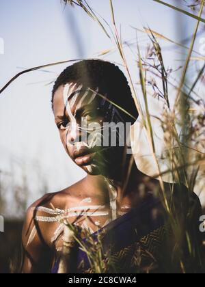 Porträt eines afrikanischen Jungen mit ethnischer Gesichtsfarbe und Dressing im Busch Stockfoto