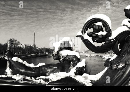 Paris im Schnee. Blick von der Alexandre III Brücke. Eiffelturm im Hintergrund. Schwarz weiß historisches Foto. Stockfoto