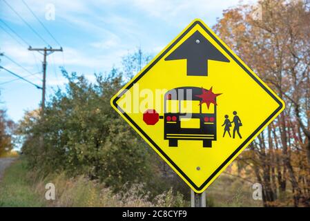 Schulbus Haltestelle vor Schild entlang einer Landstraße. Zurück zu Schule und Bildungskonzepten. Stockfoto