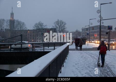 PARIS, FRANKREICH - 6. FEBRUAR 2018: Pariser Vororte unter Schnee in seltenen verschneiten Abend im Winter. Autos und Menschen überqueren Brücke mit Schnee bedeckt Stockfoto