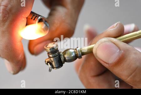 23. Juli 2020, Hessen, Frankfurt/Main: Ein Drogenabhängiger zündet in der Frankfurter Drogenhilfe "Eastside" eine Risspipe an. Die Einrichtung Integrative Drug Help (idh), die sich in einem ehemaligen Fabrikgebäude befindet, ist nach Angaben der Veranstalter die größte Einrichtung für die Hilfe bei niedrigen Schwellenwerten in Europa. Foto: Arne Dedert/dpa Stockfoto