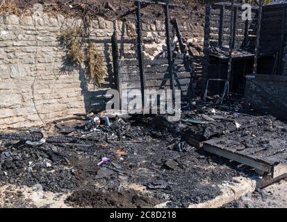 Verkohlte Überreste von Strandhütten, die in Brand geraten sind am West Cliff Beach, Bournemouth, Dorset UK im Juli begann das Feuer in der Strandhütte und breitete sich auf die Klippen aus Stockfoto