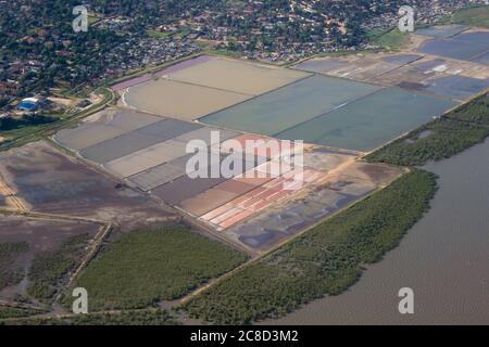 Bunte Verdunstungswannen, die für den Salzabbau in der Mündung in Katembe, südlich von Maputo, Mosambik, aus der Sicht eines Flugzeugs verwendet werden Stockfoto