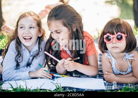 Glückliche Kinder, die im Park zusammen Kunst und Kunsthandwerk machen Stockfoto