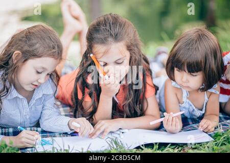 Glückliche Kinder, die im Park zusammen Kunst und Kunsthandwerk machen Stockfoto