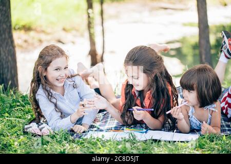 Glücklich hübsche Kinder Mädchen Spaß beim Malen im Park Stockfoto