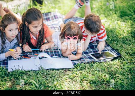 Glückliche Kinder, die im Park zusammen Kunst und Kunsthandwerk machen Stockfoto