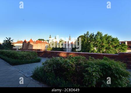 Die historischen Verteidigungsmauern der Warschauer Barbican- und Bürgerhäuser in der Altstadt im Licht der aufgehenden Sonne. Sommer. Stockfoto