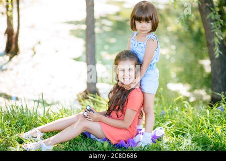 Zwei lustige Freunde spielen mit bunten zappeln Spinner auf dem Spielplatz. Beliebte Anti-Stress-Spielzeug für Kinder und Erwachsene. Stockfoto