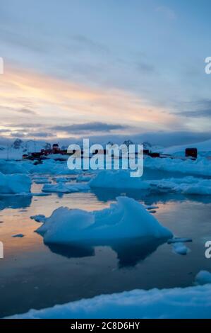 Eiskiesel mit der chilenischen Gonzalez Videla Base im Hintergrund im Abendlicht, auf dem antarktischen Festland am Waterboat Point in Paradise Bay Stockfoto