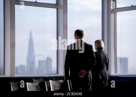 Zwei elegant gekleidete Geschäftsleute, die aus EINEM Fenster im The Shard in London schauen Stockfoto