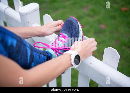 Frau bindet ihre Schnürsenkel in Vorbereitung auf ein Rennen Stockfoto