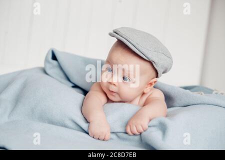 Baby liegt auf buntem Handtuch auf dem Bett Stockfoto