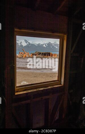 Blick durch ein Fenster von einem alten Haus, Teil der Überreste einer alten Walfangstation in Whalers Bay, in Port Foster, der Caldera von Deception Island Stockfoto