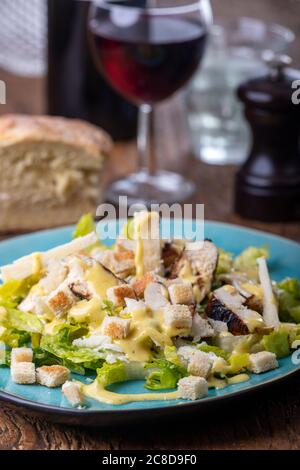 caesar Salat auf einem blauen Teller Stockfoto