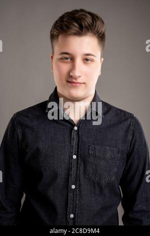 Portrait von ernst stilvolle attraktive Mann mit einem lässigen schwarzen Hemd auf grauem Hintergrund isoliert gekleidet Stockfoto