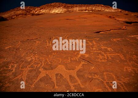 Nahaufnahme der prähistorischen Steininschriften und Petroglyphen nomadischer beduinen auf der Oberfläche roter Sandsteinfelsen des Wadi Rum Jordan. Stockfoto