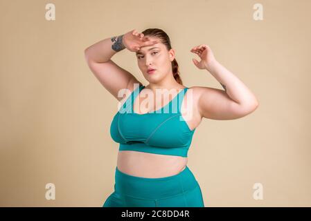 Ziemlich übergroße Frau trägt Sportkleidung posiert im Studio - schönes Mädchen akzeptieren Körper Unvollkommenheit, Beauty-Aufnahmen im Studio - Konzepte über Körper A Stockfoto