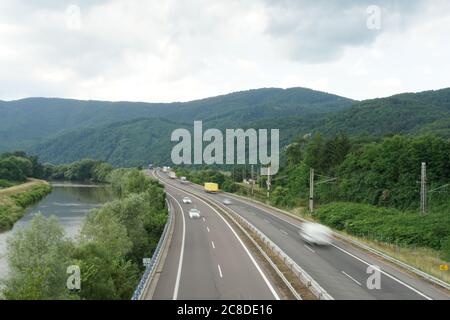 Luftaufnahme der neuen Autobahn R1 in Zarnovica, Slowakei Richtung Nitra mit Fluss Hron auf der linken Seite mit Staivnica Berge um. Stockfoto