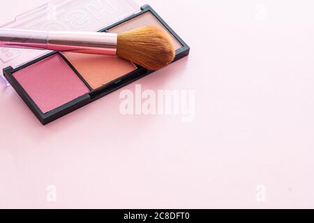 Pallete aus Pinsel in Pastellfarben und Pinsel vor pinkfarbenem Hintergrund, Nahansicht. Professionelle Werkzeuge für Make-up, Beauty-Salon, Kosmetikartikel Stockfoto