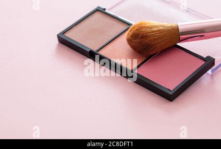 Pallete aus Pinsel in Pastellfarben und Pinsel vor pinkfarbenem Hintergrund, Nahansicht. Professionelle Werkzeuge für Make-up, Beauty-Salon, Kosmetikartikel Stockfoto