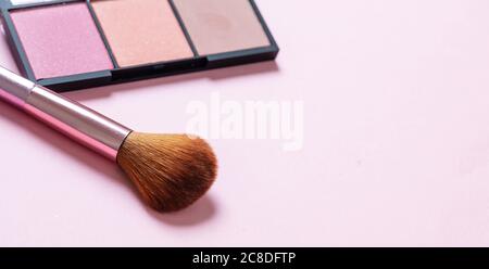 Pallete aus Pinsel in Pastellfarben und Pinsel vor pinkfarbenem Hintergrund, Nahansicht. Professionelle Werkzeuge für Make-up, Beauty-Salon, Kosmetikartikel Stockfoto