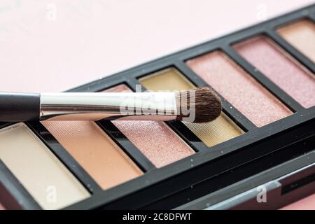 Eyesheatows pallete setzen Pastellfarben und bürsten vor pinkfarbenem Hintergrund, Nahaufnahme. Professionelle Werkzeuge für Make-up, Beauty-Salon, Kosmetikkonzept Stockfoto