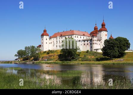 Lacko, Schweden - 23. Juni 2020: Ein Kanufahrer paddelt im Kajak am Schloss Läckö vorbei. Stockfoto