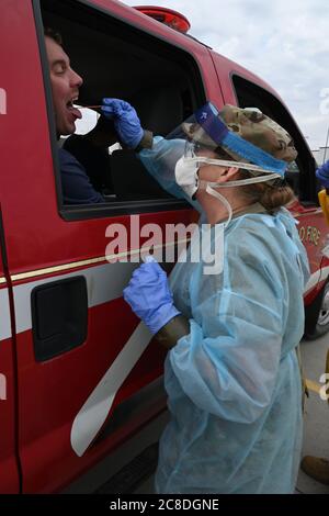 Maj. Shelley Bartow, von der staatlichen medizinischen Abteilung der North Dakota National Guard, nimmt eine Abstrichprobe eines asymptomatischen Feuerwehrmann der Fargo Fire Department, der sich freiwillig für einen COVID-19 Test auf dem Parkplatz des FaroDome, N.D., 25. April 2020, engagiert. Sie trägt persönliche Schutzausrüstung (PSA), um während der Arbeit sicher zu bleiben und die Ausbreitung des Coronavirus zu verhindern, während sie die Menschen während der Massenprüfung in ihren Fahrzeugen testet. Sie ist nur eine der N.D. Mitglieder der Nationalgarde, die mit der N.D. zusammenarbeiten Gesundheitsministerium und andere zivile Einrichtungen i Stockfoto