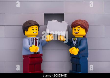 Tambow, Russische Föderation - 07. Juni 2020 Lego Geschäftsmann und Geschäftsfrau minifiguren mit grauen Ziegel bereit, die Fertigstellung der Wand Stockfoto
