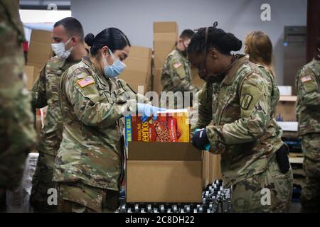 North Carolina Army National Guard Spc. Jasmin Gonzalez (links), der 1454. Transportation Company zugeordnet, und Sgt. Sha-TEISA Sharpe, der 694. Wartungsfirma zugeordnet, arbeitet zusammen, um Lebensmittel in einer Montagelinie beim Inter-Faith Food Shuttle in Durham N.C., 10. Juni 2020, zu sortieren und zu verpacken. Die NCNG arbeitet mit North Carolina Emergency Management, N.C. zusammen Ministerium für Gesundheit und menschliche Dienste und lokale Lebensmittelbanken zur Unterstützung der COVID-19-Hilfsmaßnahmen. (USA Army National Guard Foto von SPC. Hannah Tarkelly, 382. Abteilung für öffentliche Angelegenheiten/freigelassen). Stockfoto