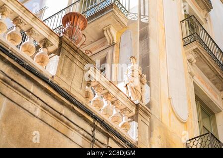 Skulptur einer Frau aus Stein auf einem Balkon in Barcelona, Spanien. Elemente der architektonischen Dekoration von Gebäuden Stockfoto