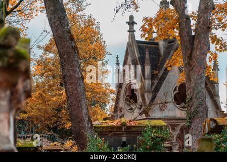 Paris, Frankreich - 14. November 2019: Steinkreuz auf dem berühmtesten Friedhof von Paris Pere Lachaise, Frankreich. Gräber von verschiedenen berühmten Menschen. Goldenes Auto Stockfoto
